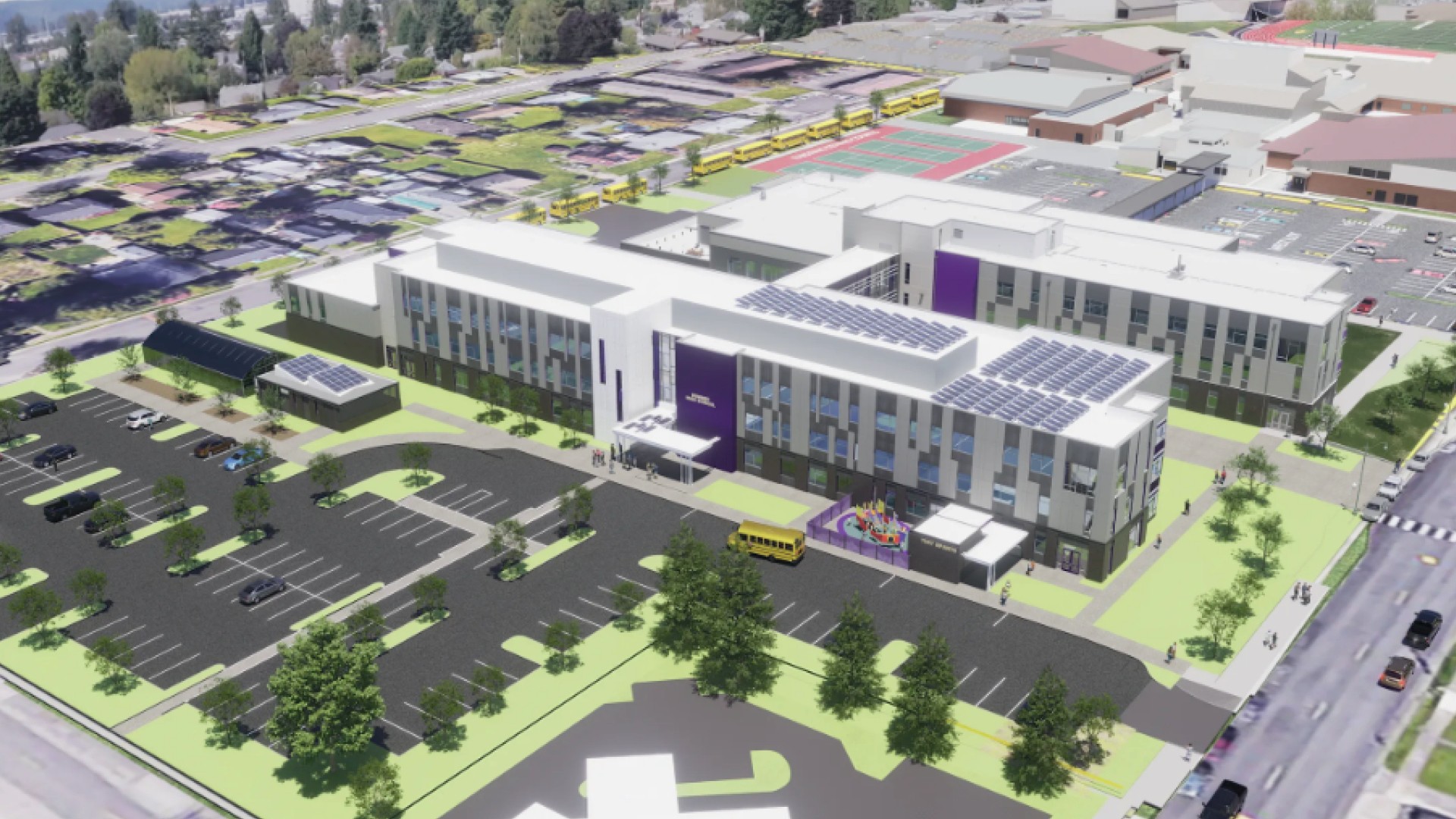 Aerial view of a modern school campus with solar panels, playground, and parking lot.