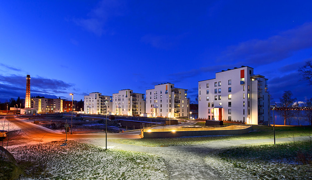 Härmälänranta Modernit kerrostalot valaistuna yöllä kirkkaan sinisen taivaan alla ja kevyttä lunta maassa.