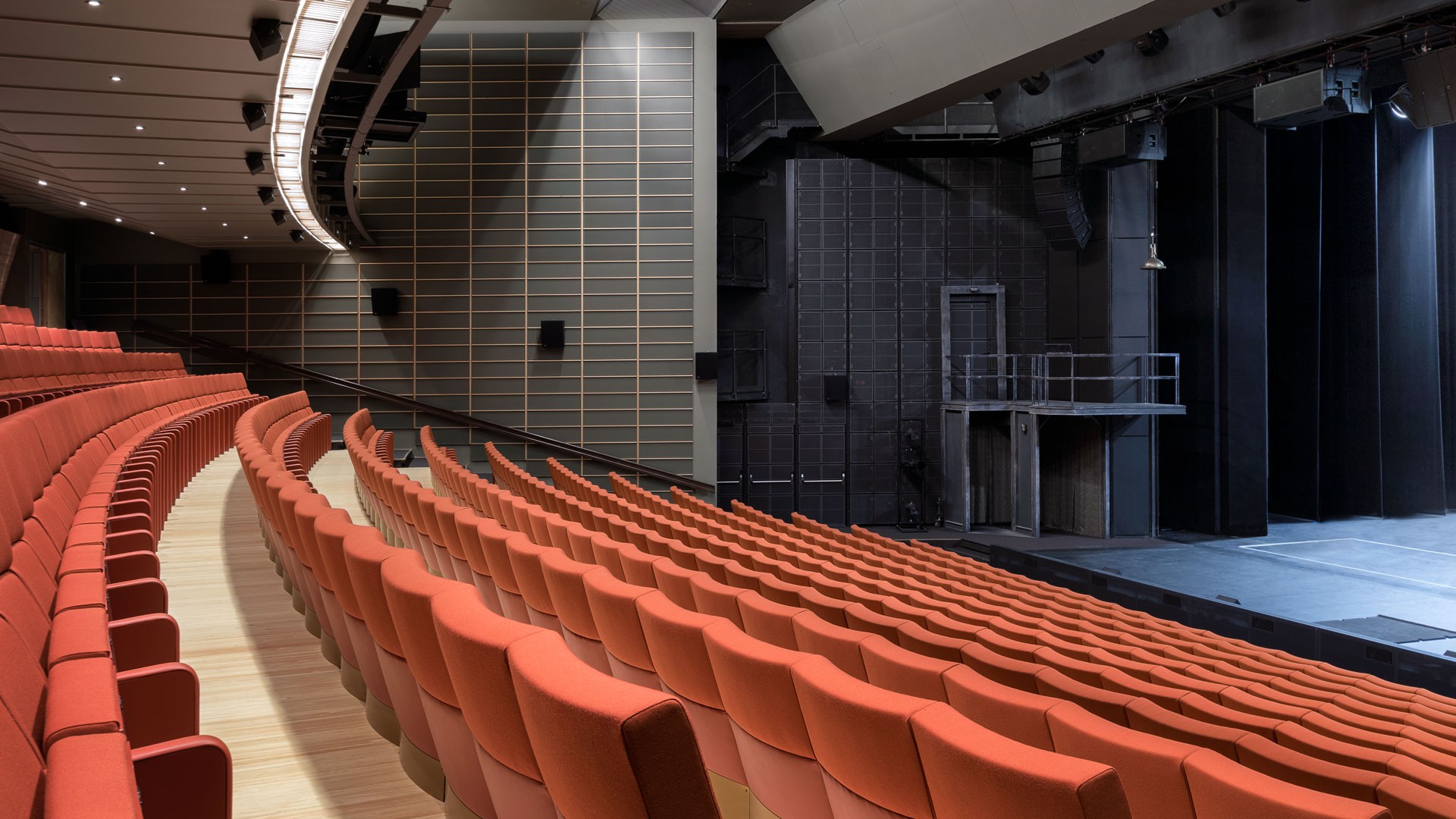 Turun kaupunginteatteri - sali Moderni teatterin sisustus, jossa on kaarevat rivit punaisia istuimia ja näkymä lavalle ja kulissien taakse.
