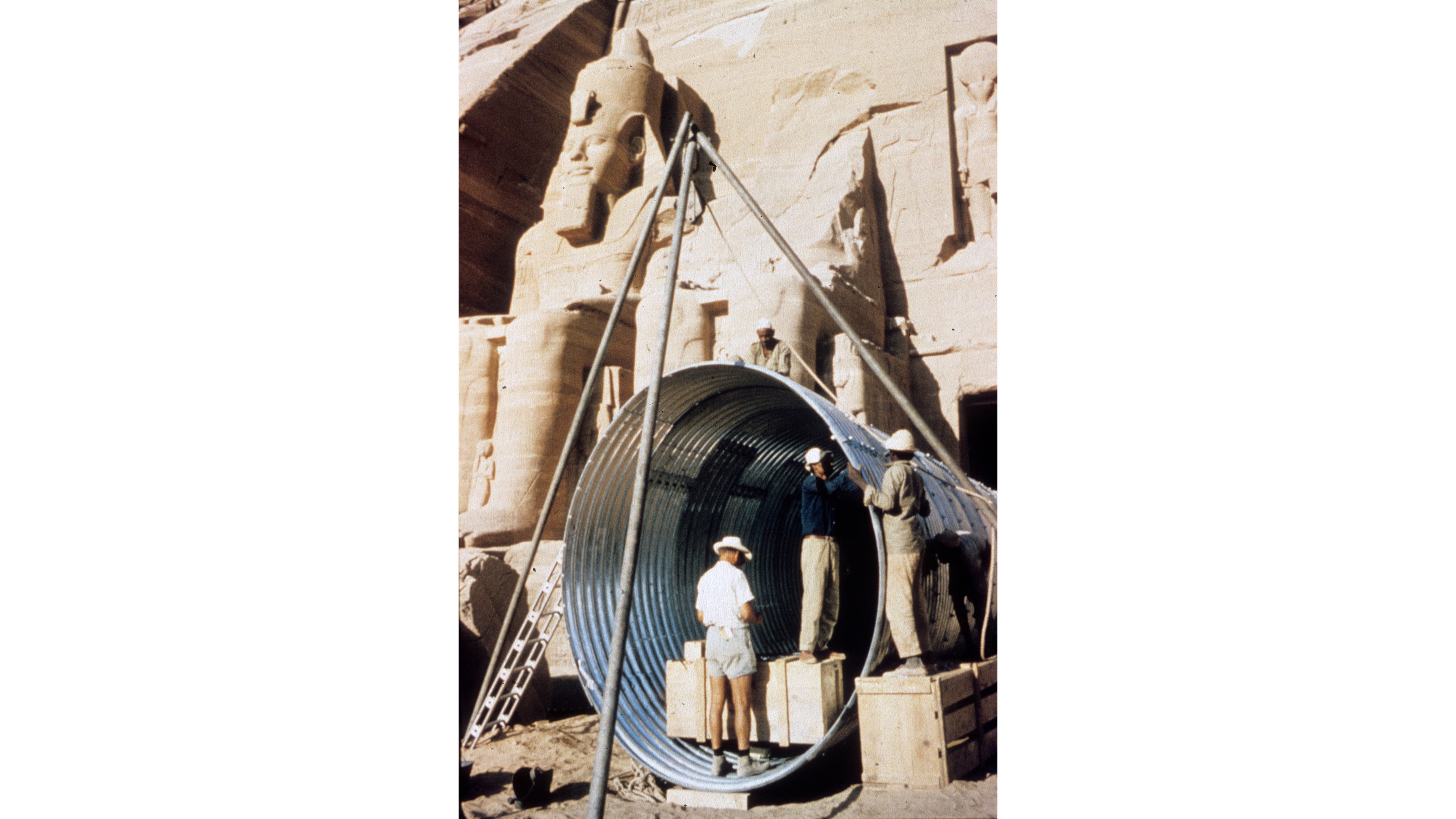 Vid Aussandammen Man i shorts och tropikhjälm står i ingången till ett egyptiskt tempel.