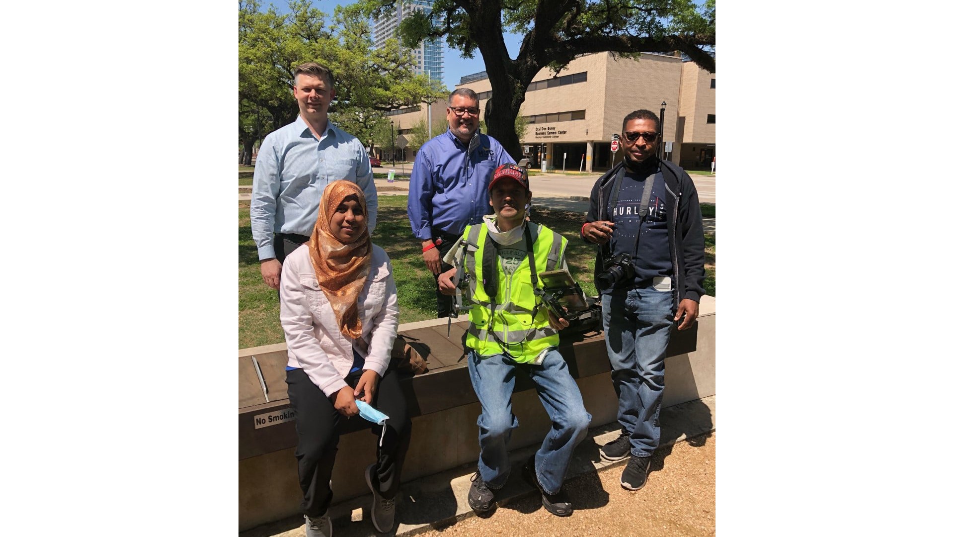 Outdoor Group Photo with Diverse Attire and Scenic Background Houston Community College students involved in the project gather with Professor and Founder and Associate Director of the Reality Collab Rubén Durán, and Senior Preconstruction Technologist Edwin Bailey.