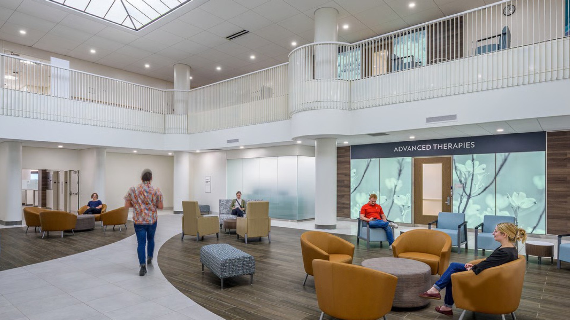 Modern medical facility waiting area with patients seated and walking under bright lights.
