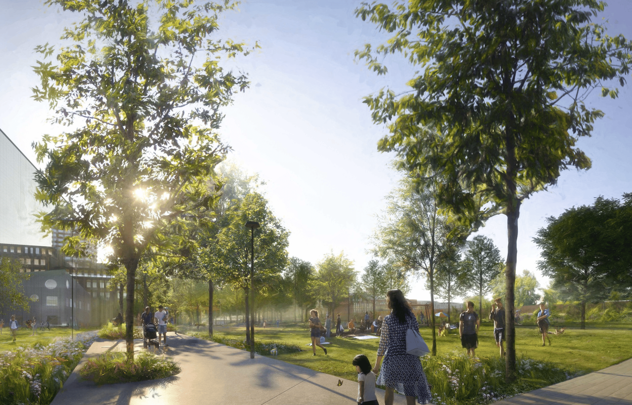 Solig parkscen med familjer som promenerar och barn som leker på en asfalterad stig.
