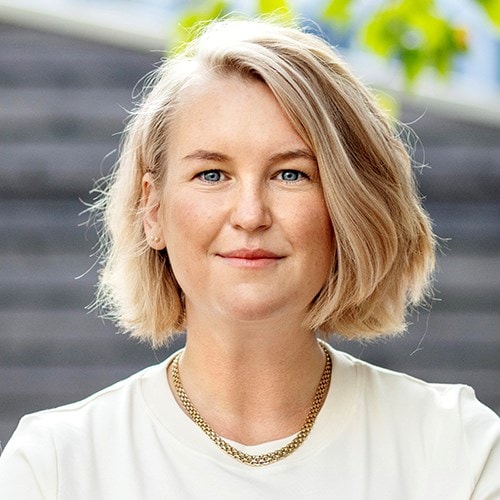 Bild på ung person med kort ljust hår och blå ögon.