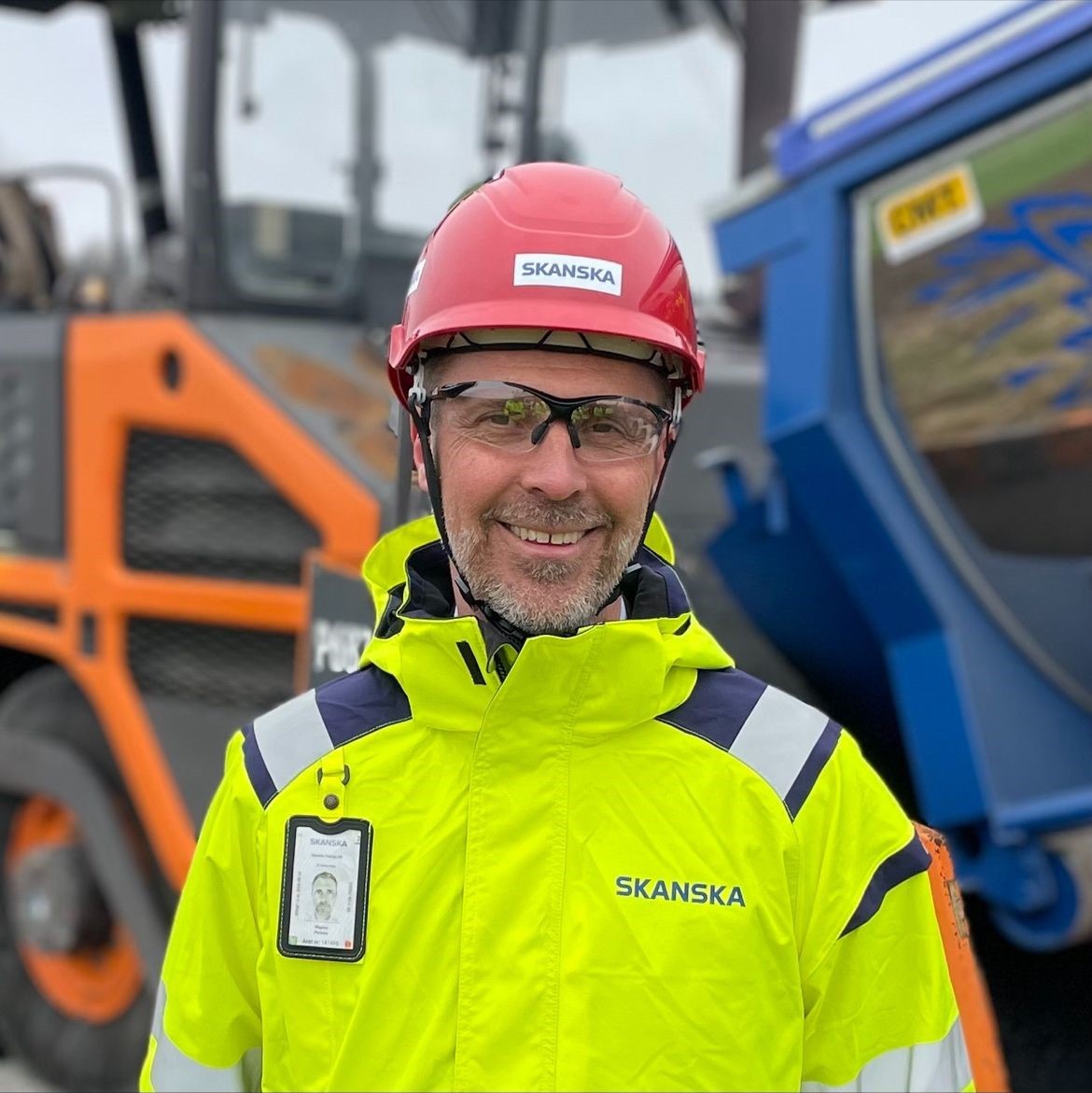 Magnus Persson, vd Skanska Sverige AB Leende byggnadsarbetare i högsynlighetsjacka och röd hjälm på byggarbetsplats.
