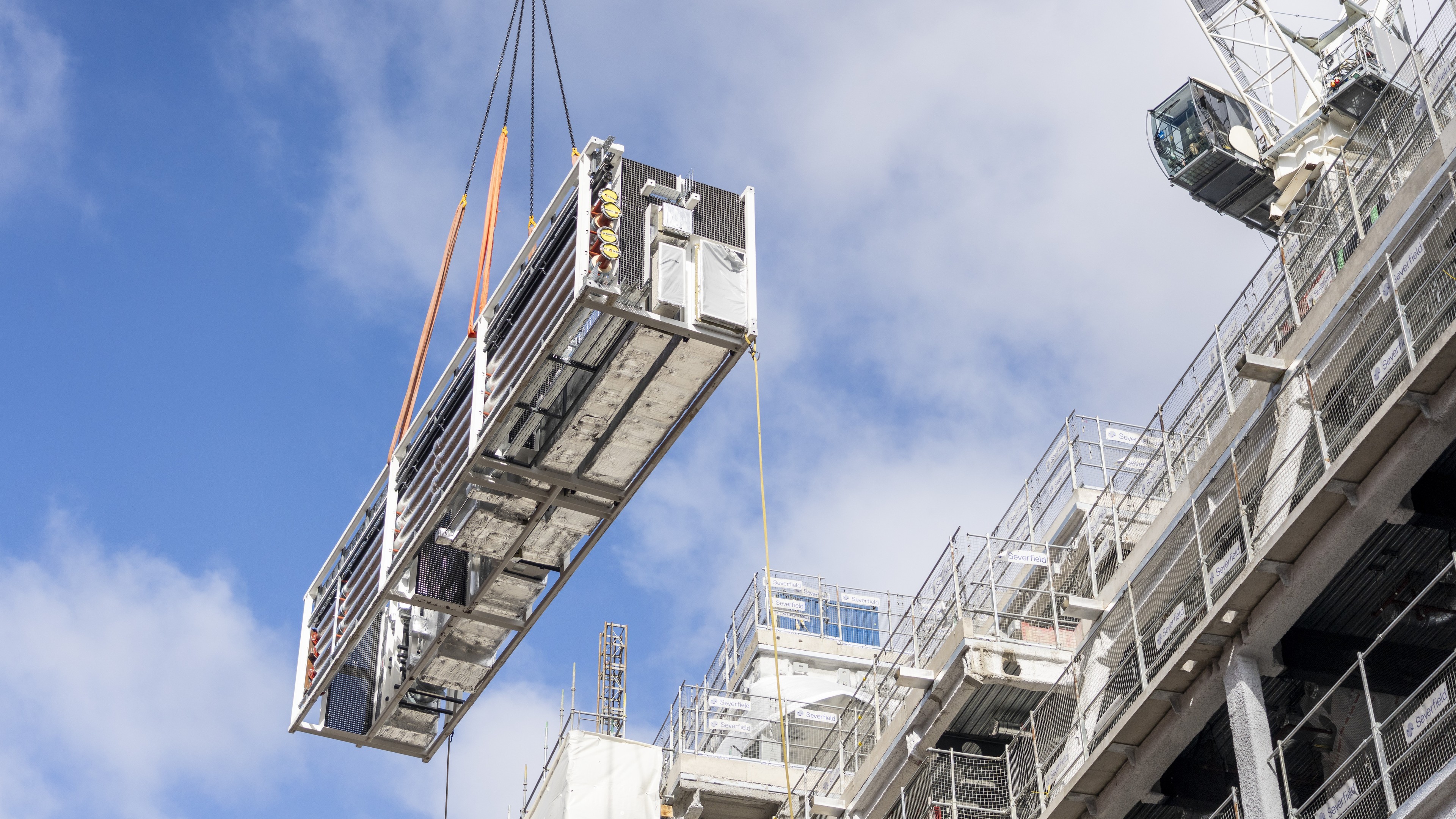Off-site manufactured MEP riser being installed MEP riser being lifted into the sky