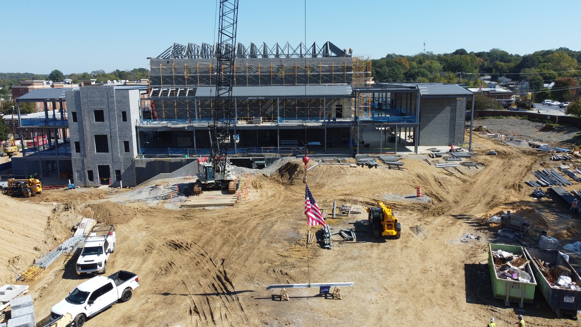 Building Construction Progress - Aerial Site View Construction site with a large building under development and heavy machinery.
