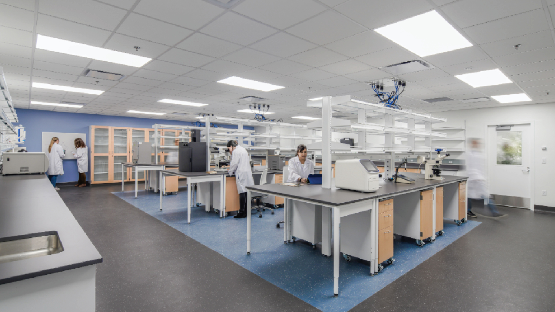 Modern Scientific Laboratory with Researchers and Equipment Modern laboratory with scientists working at benches, equipped with advanced instruments.