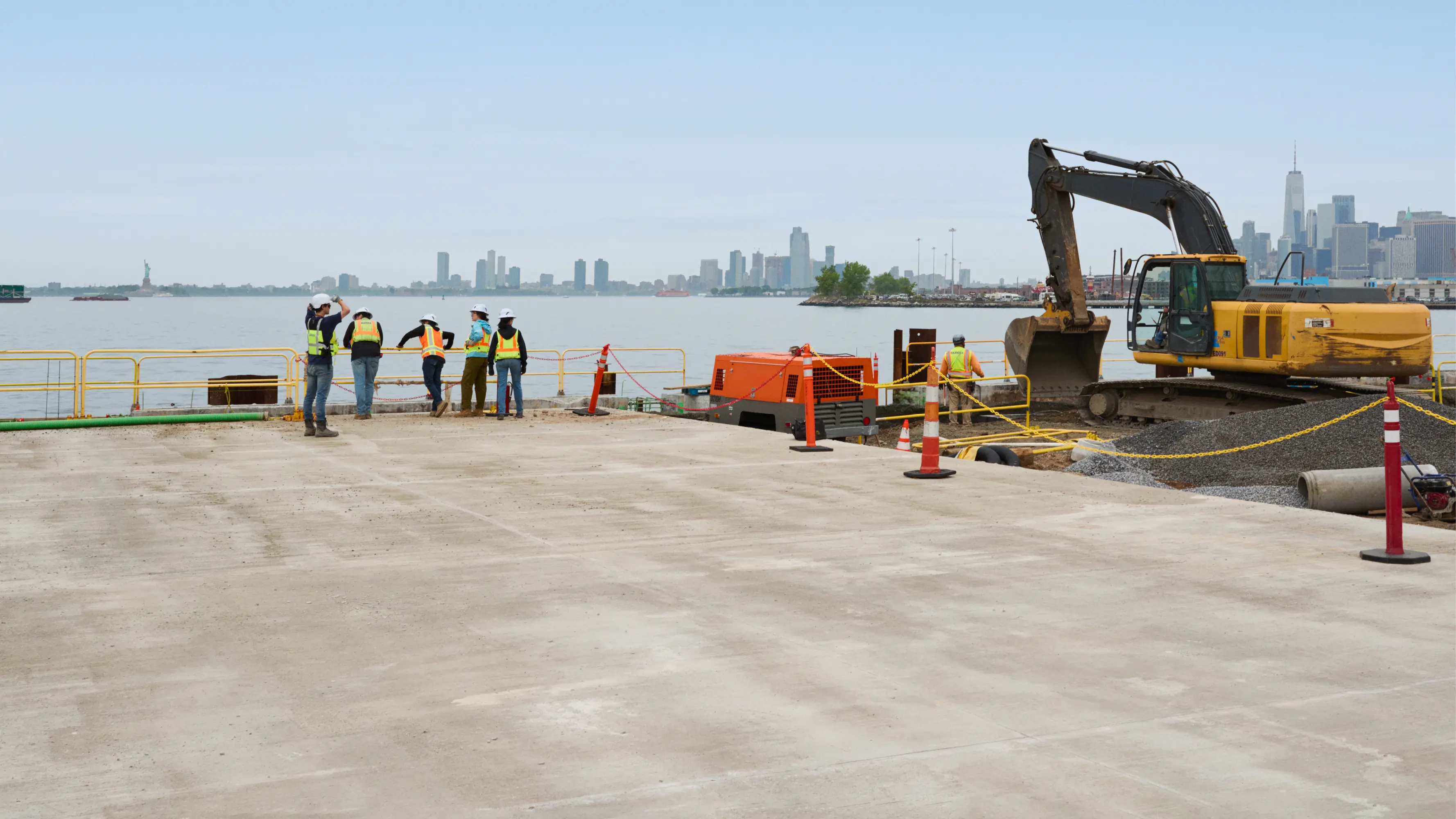 A Skanska construction site with a city skyline behind it