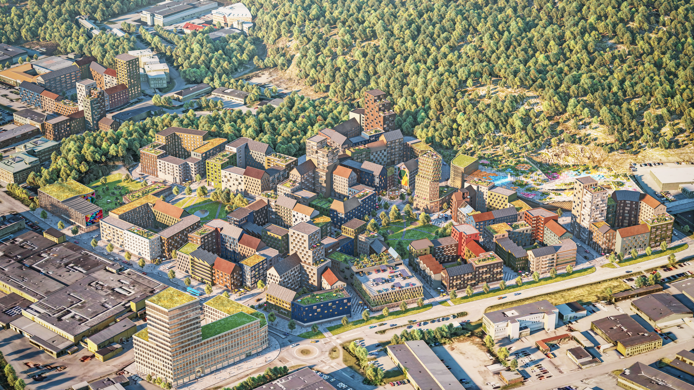 Södra Änggården kombinerar en stadsatmosfär med närheten till det vidsträckta naturområdet Änggårdesbergen. Bild av Okidoki Arkitekter. Flygvy över ett modernt bostadskomplex omgivet av frodig grönska och urban infrastruktur.